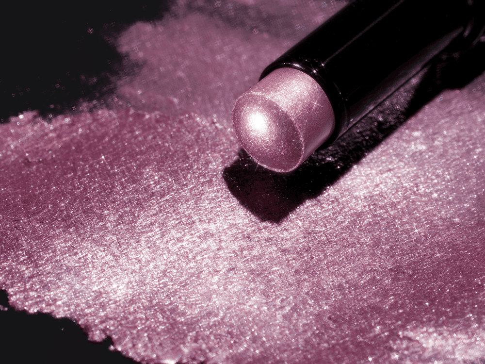 Close-up of Illumina Jelly Eyeshadow Stick with a shimmering pink-purple swatch on a black background.