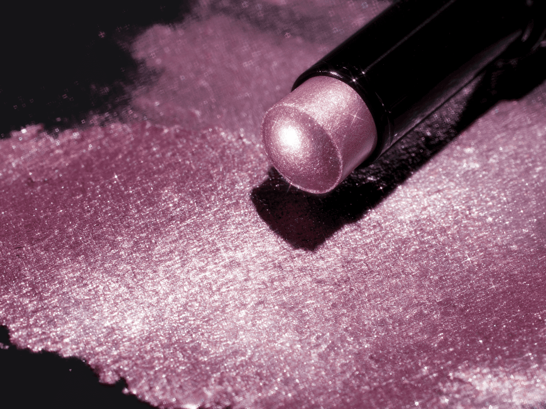 Close-up of Illumina Jelly Eyeshadow Stick with a shimmering pink-purple swatch on a black background.