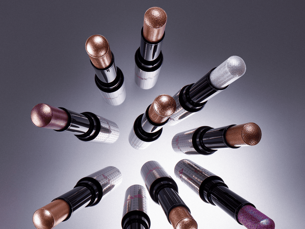 Fingertip tapping the edge of purple metallic eyeshadow on a closed eyelid.  